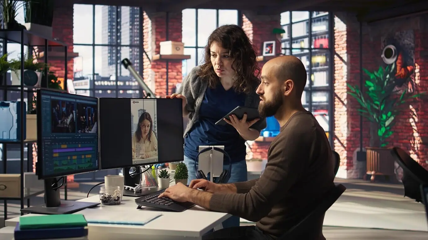 Ein professioneller Editor nutzt in einem kreativen Büro KI-gestützte Software und PC-Reels.